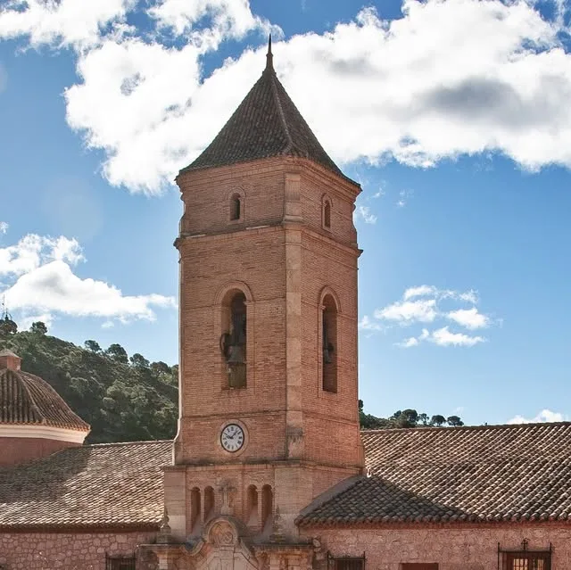 Torre del santuario de Santa Eulalia recortada sobre el cielo, carretera arriba